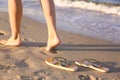 Closeup of  and flip flops on sand near sea, space for text. Beach accessories Royalty Free Stock Photo