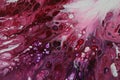 Closeup of a flowing abstract acrylic pour painting in shades of pink and white.