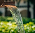 Closeup of a flowing water fountain in the park on a sunny day Royalty Free Stock Photo