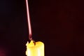 Closeup focus shot of a lone burning candle in a dark environment Royalty Free Stock Photo