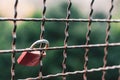 Closeup focus shot of a love lock attached to a grate