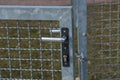 Closeup focus shot of a metal mesh gate handle