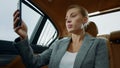 Closeup focused executive woman making video chat at vehicle. Woman using mobile Royalty Free Stock Photo