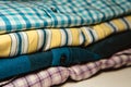 Closeup of folded flannel and striped shirts on the table Royalty Free Stock Photo