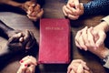 Closeup of folded hands and Holy Bible Diverse religious shoot