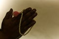 Closeup of folded hands praying with a rosary Royalty Free Stock Photo