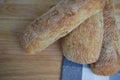 Closeup food photography of fresh home made artisan ciabatta bread on a wood board with blue check pattern table cloth