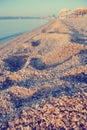 Closeup of footprints on the pebbly beach in summer; faded, retro style