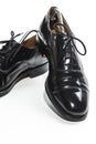 Closeup of Formal Male Stylish Black Polished Oxford Leather Laced Shoes Placed Together Over White