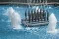 Closeup of fountain nozzles with water sprays and splashes. Aqua geysers in pool of waterworks Royalty Free Stock Photo