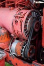 Closeup of four cylinder diesel tractor engine with visible belt rusty tracks hydraulic parts and wiring red paint in sunny autumn Royalty Free Stock Photo