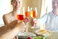 Closeup of four glasses with rose wine being clinked together