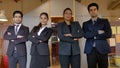 Closeup of four Indian business people standing in a line with their arms crossed, smiling Royalty Free Stock Photo