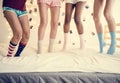 Closeup of four pairs of teen legs with socks jumping on the bed