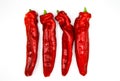 Closeup of four red ripe bell peppers in a row, white background Royalty Free Stock Photo