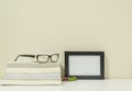 Closeup frame for photo with pile of book on desk in living room background