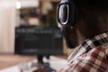 Closeup on freelance coder with wireless headphones listening to music while developing software