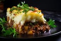 Closeup of fresh baked homemade cottage Shepherd's traditional pie with greens on black