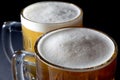 Closeup of Fresh Beer with Foam in Two Beer Glasses On Black Background Royalty Free Stock Photo