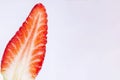 Closeup of a fresh, bright red strawberry cut in half on a white background, horizontal and copy space Royalty Free Stock Photo