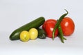 Closeup of fresh cucumbers, lemons, chilis, and tomatoes isolated on a white background Royalty Free Stock Photo