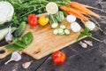 Closeup of fresh farmers market locally grown organic chopped vegetables on a cutting board. Wooden background.