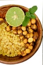 Closeup the fried yellow gram split lentils with black gram and sliced lemon ,mint in the red wooden bowl over out of focus white Royalty Free Stock Photo