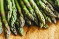 Closeup of fresh green asparagus on vintage wooden table. Cooking vegetarian food with organic ingredient on rustic board. Healthy Royalty Free Stock Photo