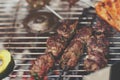 closeup on fresh kofta lamb meat spits with mint that are grilled on a charcoal grill