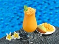 Closeup of a fresh mango cocktail on the side of the pool Royalty Free Stock Photo