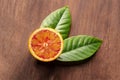 A closeup of a fresh organic blood orange, shot from above on a dark rustic wooden background Royalty Free Stock Photo