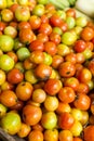 Closeup of fresh and partially ripe Philippine tomatoes for sale at a small market stall