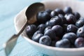 Closeup of fresh ripe blueberries in a bowl on a blue wooden background Royalty Free Stock Photo