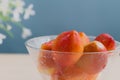 Closeup of fresh ripe nectarines in glass bowl, blue blur background Royalty Free Stock Photo