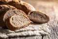 Closeup of fresh slices of organic homemade bread loafs on a rustic cloth and wooden table