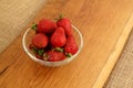 Closeup of fresh strawberries in glass bowl on wooden plate. Rustic style dessert Royalty Free Stock Photo