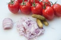 fresh tomatoes, onions and pickles on plastic cutting board Royalty Free Stock Photo