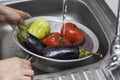 Closeup of fresh vegetables washed at a sink in a colander