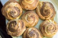 Closeup of freshly baked round homemade cinnamon buns lying on a plate, top view, flat lay, food and baking background Royalty Free Stock Photo