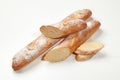 Closeup of freshly baked whole and sliced wheat baguettes isolated on white background. Main staple. Artisanal Royalty Free Stock Photo