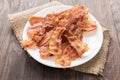 Closeup of fried bacon strips on white plate Royalty Free Stock Photo