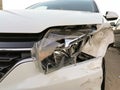 Closeup of front damaged bumper of a white accident car