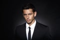 Closeup front portrait of a handsome confident businessman wearing suit standing over black background. Royalty Free Stock Photo