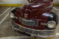 Closeup of the front view of a red and black vintage Nash 600 car in a garage