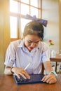 Closeup front view of Thai girl student using and study on tablet at school Royalty Free Stock Photo