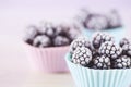 Closeup frozen blackberry in silicone forms in pastel colors on table