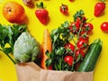 Closeup of fruits and vegetables in grocery paper bag against yellow background Royalty Free Stock Photo