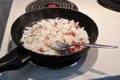 Closeup of frying onions and bacon in a pan Royalty Free Stock Photo