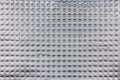 Closeup full-frame background and texture of aluminum coated butil rubber sheet with square pattern. Royalty Free Stock Photo