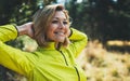 Closeup fun girl exercising outdoors in sun summer day, smile fitness woman stretching exercises training outside in park